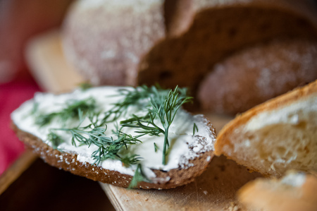 Sliced baguette and round rye black bread. Sandwich with bread, butter and dill. White loaf and rye breadの写真素材