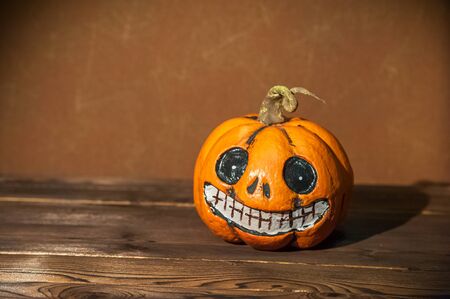 Scary halloween card with pumpkin closeup. Pumpkin, lit candles, a candlestick, copy space.の写真素材