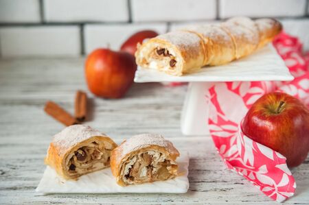 Apple strudel with apples, cinnamon closeup and copy space. Thanksgiving Meal Concept. Apple pie with icing sugar in a cut and whole.の写真素材