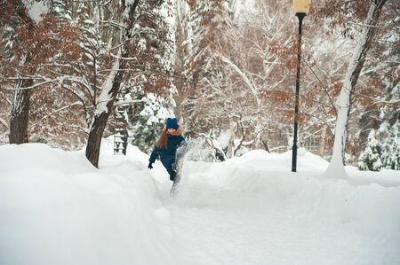 Girl in the winter forest close-up and copy space. A child plays in the winter with snow.の写真素材
