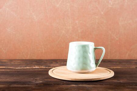 Clay cup on a wooden board on a dark background.の写真素材