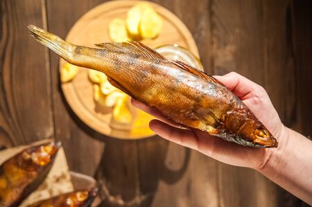 Beer glass with beer and hot smoked fish close-up. Beer mug with beer and potato chips, crackers on...
