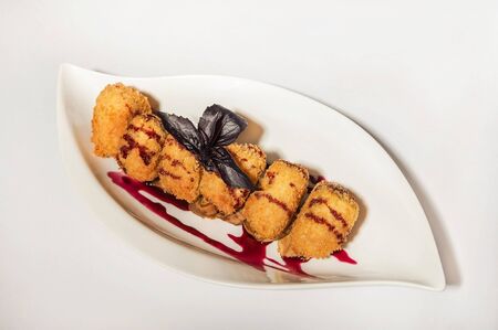 Camembert in a restaurant close-up. Fried breaded camembert with berry sauce on a white plate and copy space.の写真素材