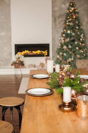 Christmas living room decor and copy space. Rustic living room with a table set for Christmas. Details of a Scandinavian living room with a festive table.の写真素材