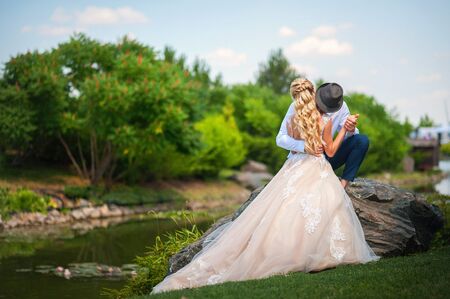 Loving couple in the summer on the nature. Newlyweds on a summer walk in the park. Wedding Ukrainian couple in Dnieper.の写真素材
