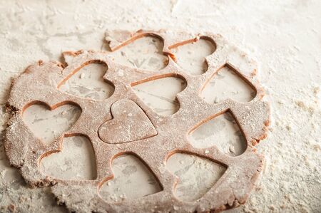 The process of making gingerbread. Flat lay flour heart dough. Texture of the dough for cookies...