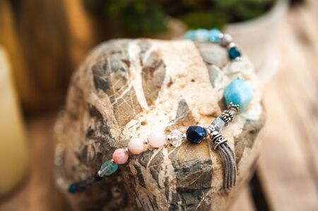 Bracelets made of natural stones on textured stones. The mysticism of amulets. Esoterics in handmade bracelets close-up and copy space.の写真素材