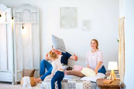 Happy family at home. Father's Day and Mother's Day. Mom, dad and daughter in a rustic style interior.の写真素材