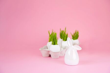 Easter concept with eggs and bunny on a pink background. Eggshell grass, spring, Easter. Festive concept close-up and copy space on a pink background.の写真素材