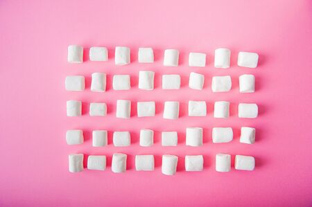 Marshmallows close-up and copy space on a pink background.の写真素材