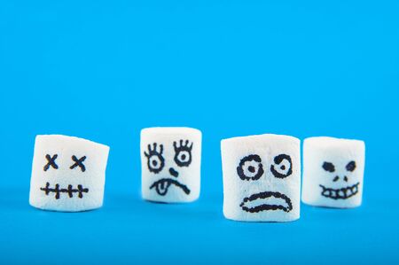 Marshmallows close-up and copy space on blue background. Marshmallows for Halloween emoticons.の写真素材