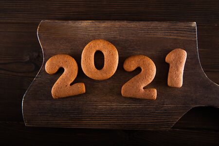 Concept with marshmallows in a mug and gingerbread cookie on a dark background. Christmas, coffee, tea, mug, marshmallows, cozy. Happy new year 2021. Winter concept close-up and copy space on dark bacの写真素材