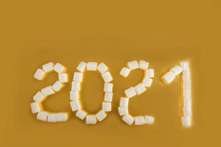 Marshmallows 2021 on yellow background close up and copy space. Marshmallow New Year 2021 on a gold background.の写真素材