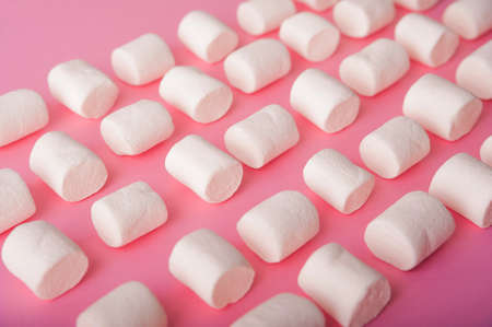 Marshmallows on a pink background close up and copy space. Marshmallow pattern top view on pink background.の写真素材