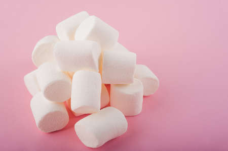 Marshmallows on a pink background close up and copy space. Marshmallow pattern top view on pink...