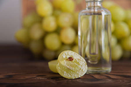 Cold pressed grape oil. Organic bio care products with natural ingredients. Close-up grapes and copy space. Halved grapes and grape seeds.の写真素材