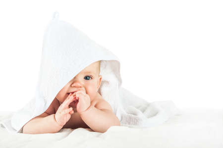 Close-up child in white towel isolated on white background. Bathing babies and restful sleep. funny toddler.の写真素材