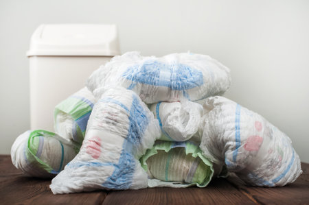 Diapers waste, dirty diapers in garbage pail Disposing of used baby nappies. Environmental Impact of Disposable Diapers. Pollution of the environment, soil and waterの写真素材