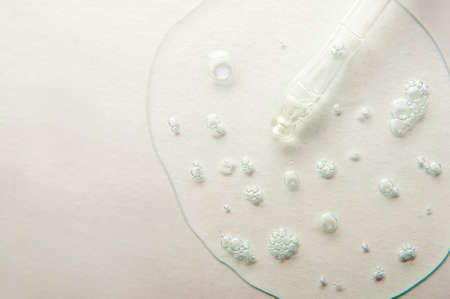 Pipette on light background in serum gel with oxygen bubbles close up