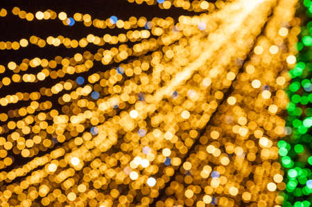 Christmas background gold lights in defocus. Yellow lights on black background place for textの写真素材
