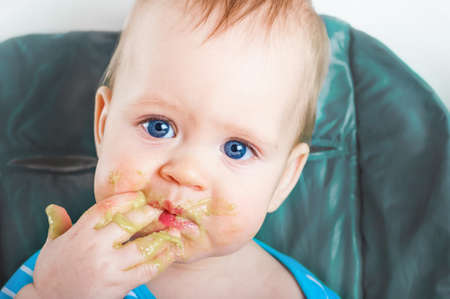 Handsome toddler licks his hand close-up. Baby complementary feeding, food allergy, intolerance...