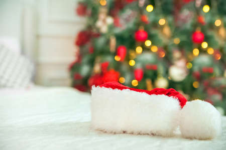 Santa Claus hat close-up on the background of New Year's lights and Christmas trees.の写真素材