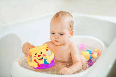 Happy toddler boy playing in bathroom close-up and copy space. Bathing babies concept.の写真素材