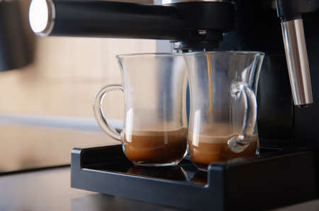 Two transparent cups coffee close-up front view. Home coffee maker and process of making coffee drink.の写真素材