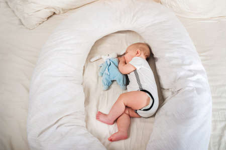 Cute baby sleeping on bed close-up and copy space. Child 6 months old, colic, teething.の写真素材
