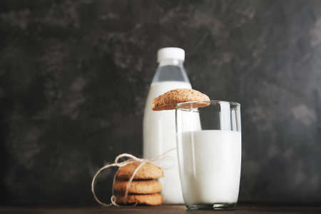 Glass of milk for Santa Claus and Christmas cookies on dark background close-up and copy space concept.の写真素材