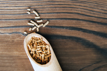Uncooked buckwheat tea in wooden scoop on wooden background close-up and copy space.の写真素材