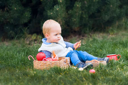 Cute toddler eating christmas cookies and milk in garland decorated backyard.の写真素材