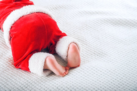 Baby legs close up. Child in Santa Claus comstume is crawling.,,の写真素材