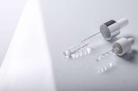 Pipette on light background close-up. Close-up of dropper for cosmetics and medicine with empty space.の写真素材
