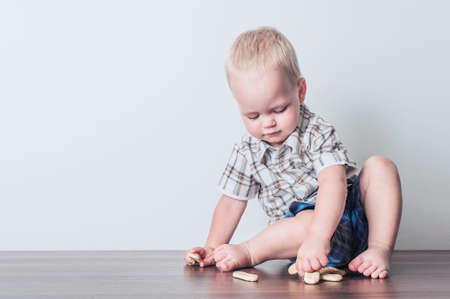 Toddler boy in blue shorts and shirt eating cookies close-up and copy space.の写真素材