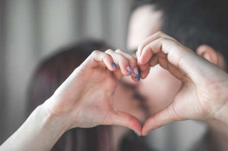 Loving couple at home in bedroom together. Romance, touching, kissing.の写真素材