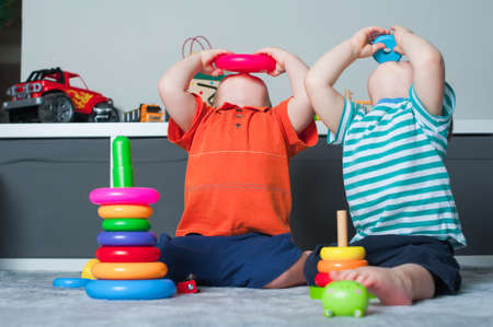 Toddler boys plays in playroom with educational toys.の写真素材