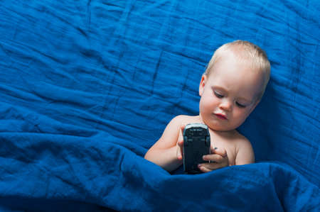 Toddler boy on bed with toy before going to bed. Self-falling asleep infants, children's night...