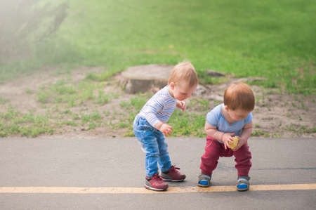 Toddler boys walk and play outside in spring..の写真素材