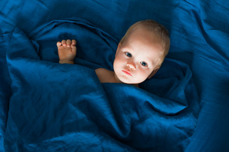 Toddler boy on bed with toy before going to bed. Self-falling asleep infants, children's night terrors.の写真素材