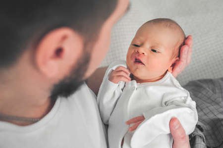 Newborn baby and young dad close up. Baby care concept, newborn weight, diapers, napkins,...