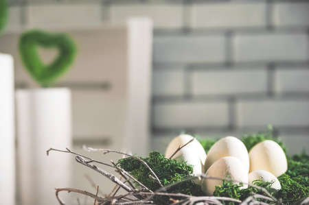 White unpainted eggs in moss and a wreath. Happy eco friendly Easter. greeting card.の写真素材