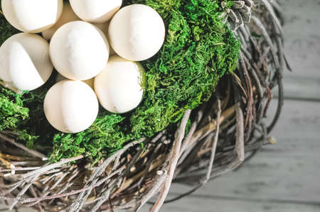 White unpainted eggs in moss and a wreath. Happy eco friendly Easter. greeting card.の写真素材