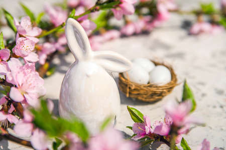 Spring blossom, Easter concept, miniature bunny, flowering tree close-up and copy space. Pink...