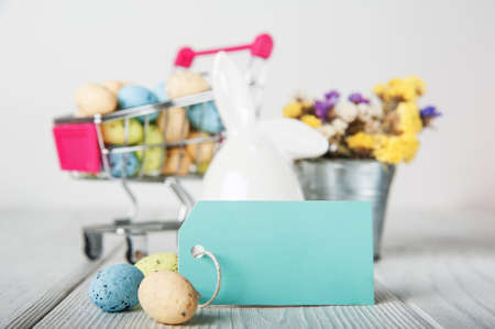 Happy Easter greeting card. Rabbits, colorful eggs, spring flowers with tag for text.の写真素材