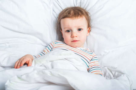 Boy Toddler in bed close-up. Healthy or sick child..の写真素材