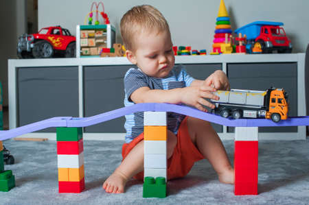 Toddler boy plays in playroom with educational toys.の写真素材