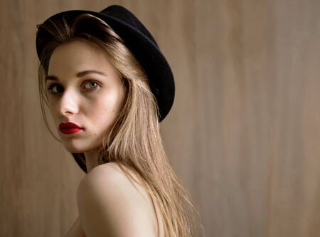 Beautiful woman in black hat. Retro fashion.
