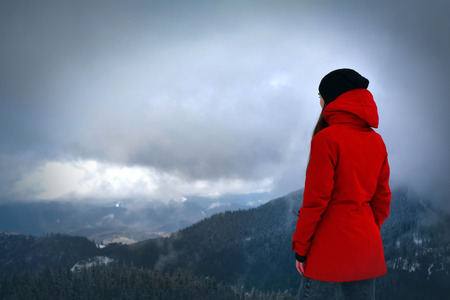 The woman on the mountain top looking in the distance.
