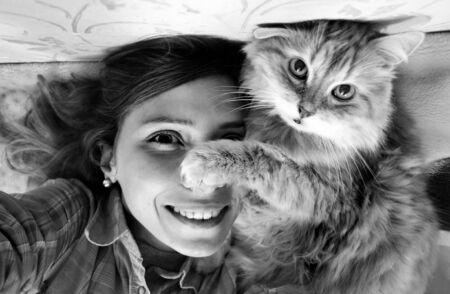 Woman taking photo of herself and her cat.の写真素材